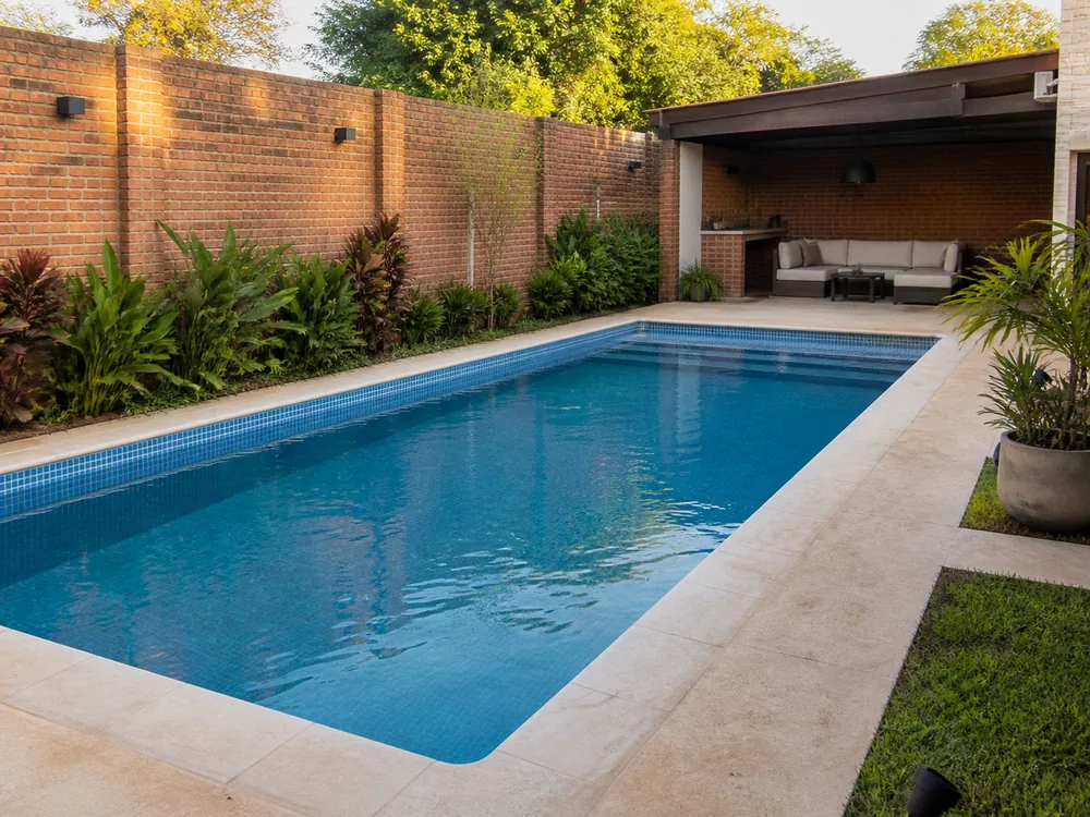 Piscina de hormigón con vereda y jardín